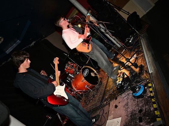 Wide-angle shot of the full band on the Spinning Top stage