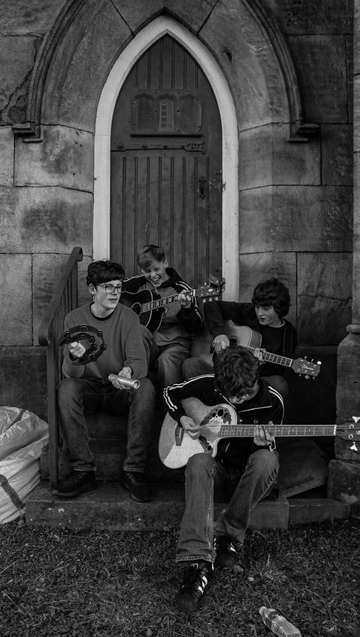 Manchester indie rock four-piece The Fleecers playing an acoustic set on the steps of a Stockport church