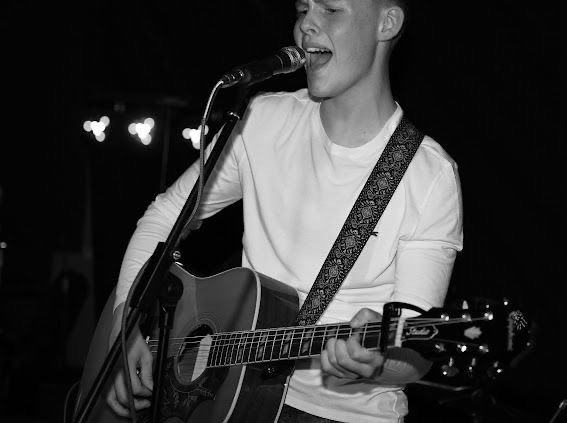 Max Thornhill singing over an acoustic guitar
